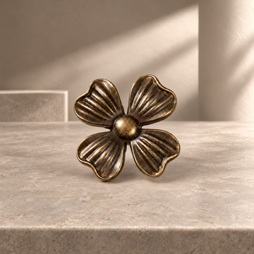 Antique Brass Petal-Design Solid Brass Cabinet Knob on a neutral stone studio background
