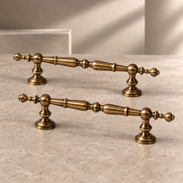 Turned Spindle Cabinet Pull & Knob — Antique Brass on a neutral stone studio background
