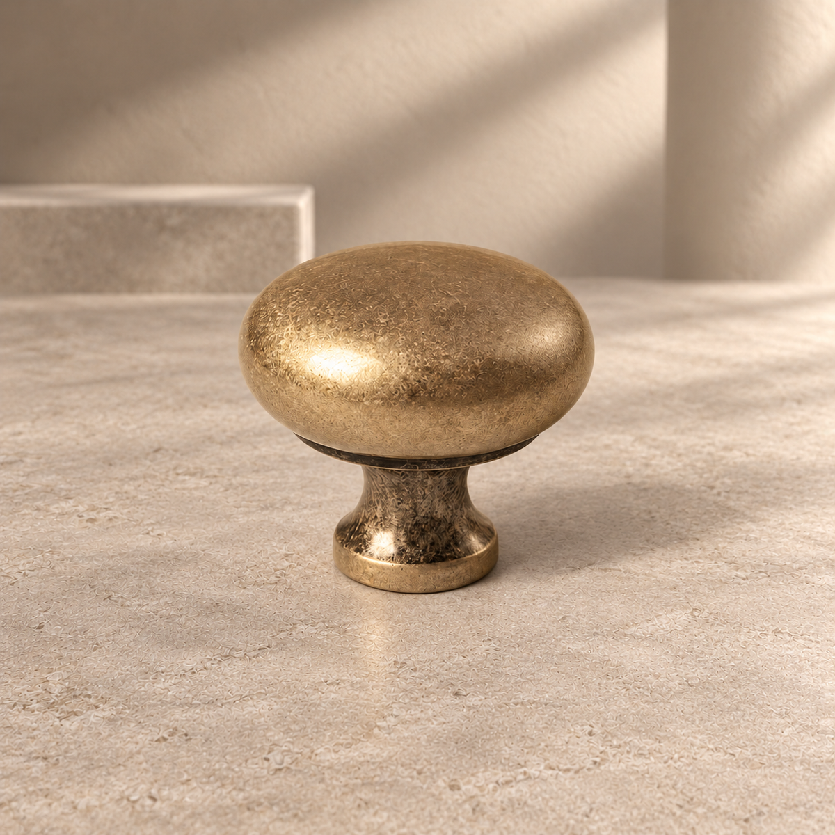 Minimalist Solid Brass Cabinet Knob — Antique Brass Finish on a neutral stone studio background