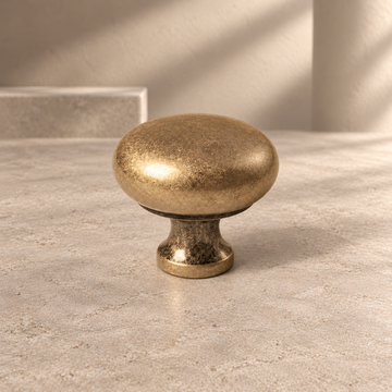 Minimalist Solid Brass Cabinet Knob — Antique Brass Finish on a neutral stone studio background