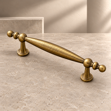 Solid Brass Arc Cabinet Pull & Knob — Antique Brass Finish on a neutral stone studio background