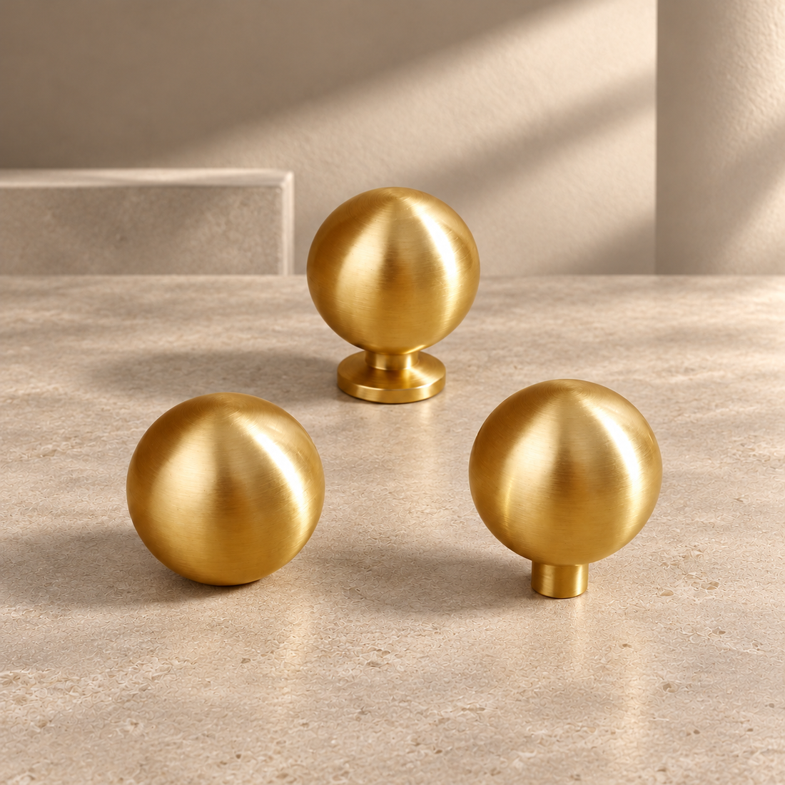 Solid Polished Brass Round Cabinet Knob — Minimalist Ball Design on a neutral stone studio background