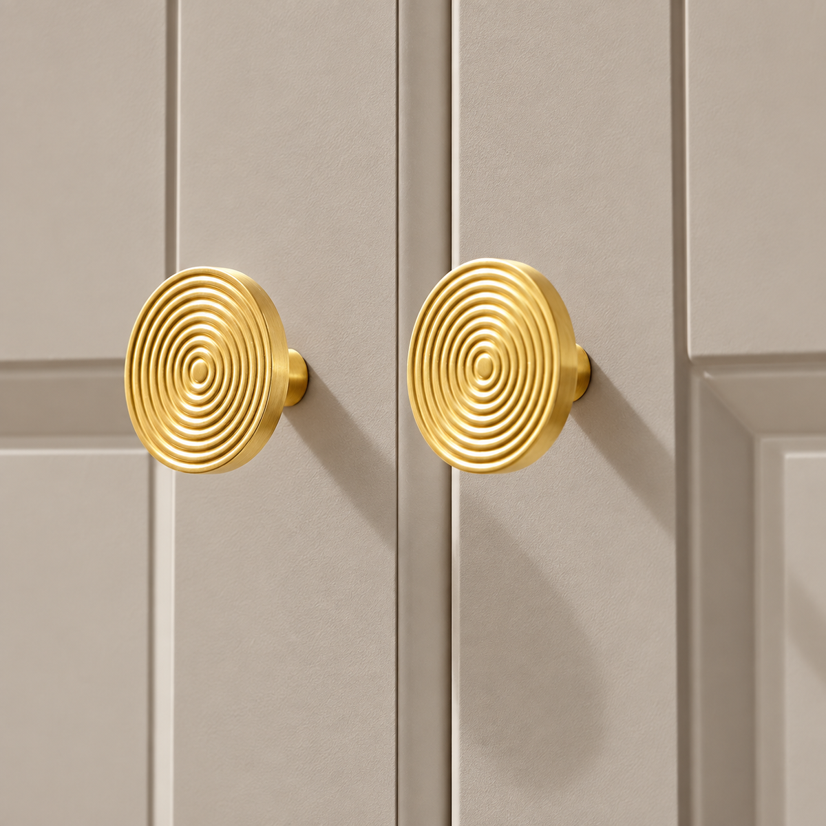 Brass concentric-ring cabinet knobs installed on taupe cabinet doors