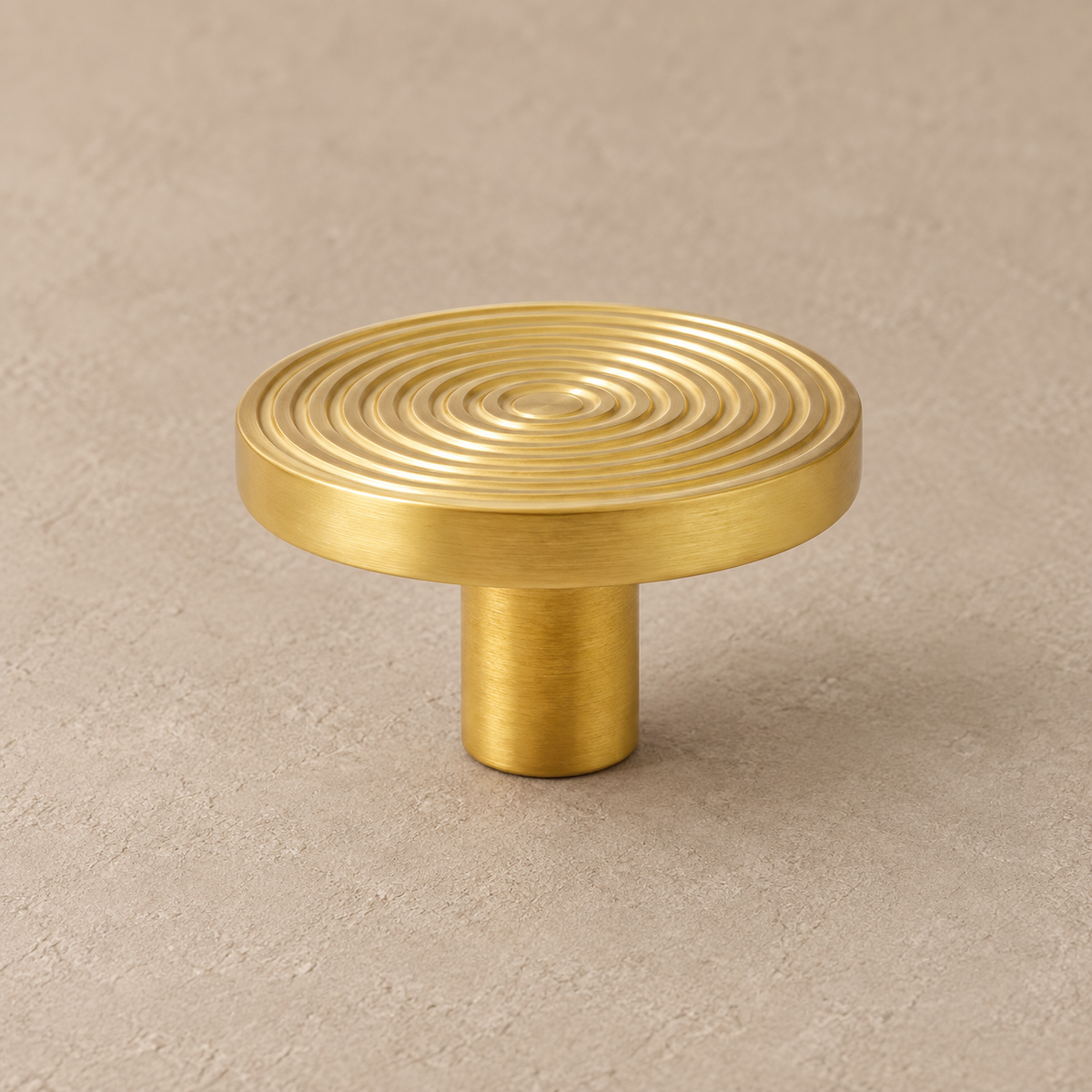 Brass swirl cabinet knob with cylindrical stem on taupe plaster