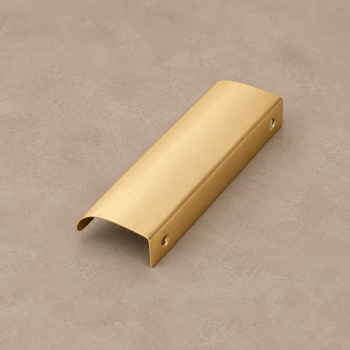 Brushed brass cabinet finger pull on taupe studio background