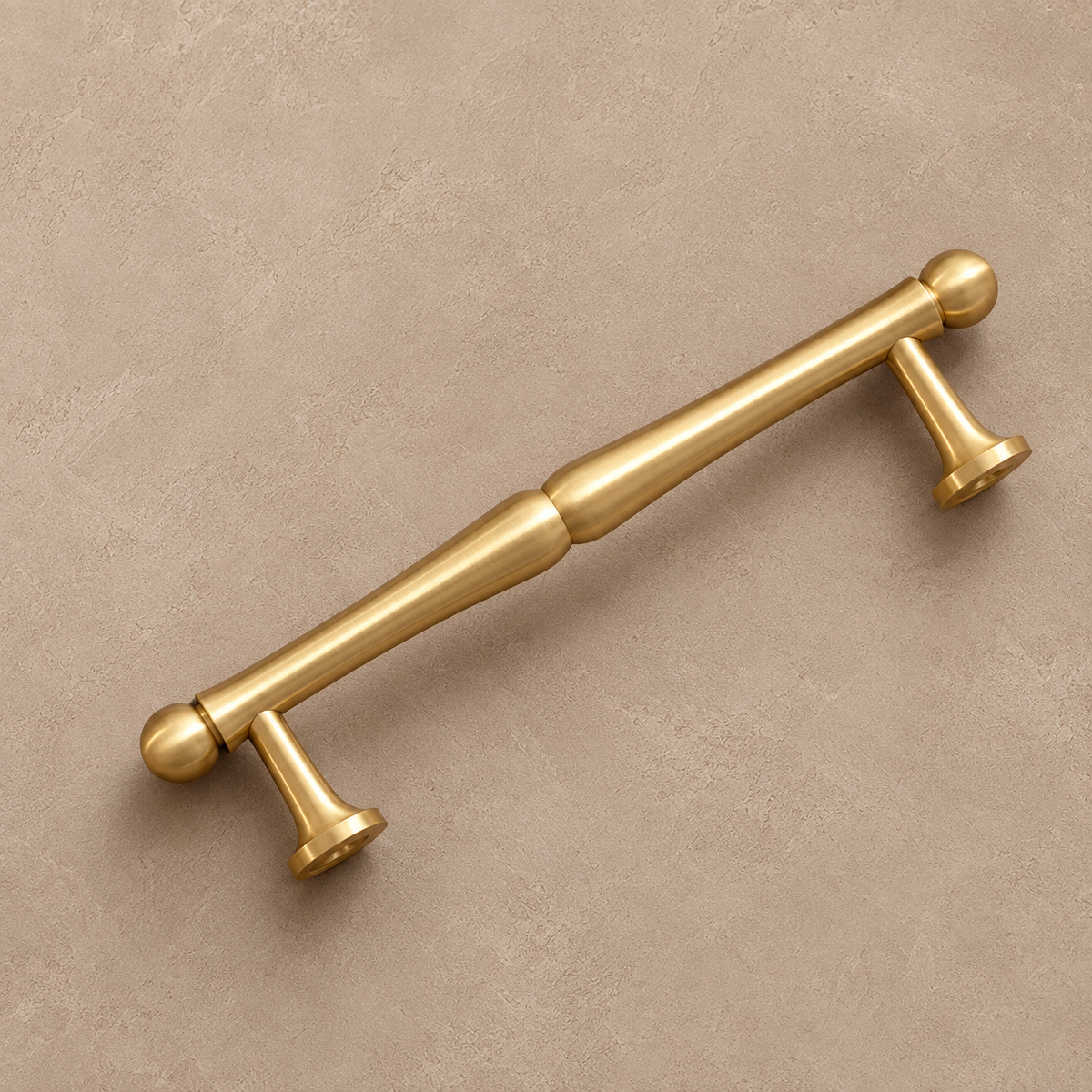 Angled view of brushed brass cabinet pull with ball ends