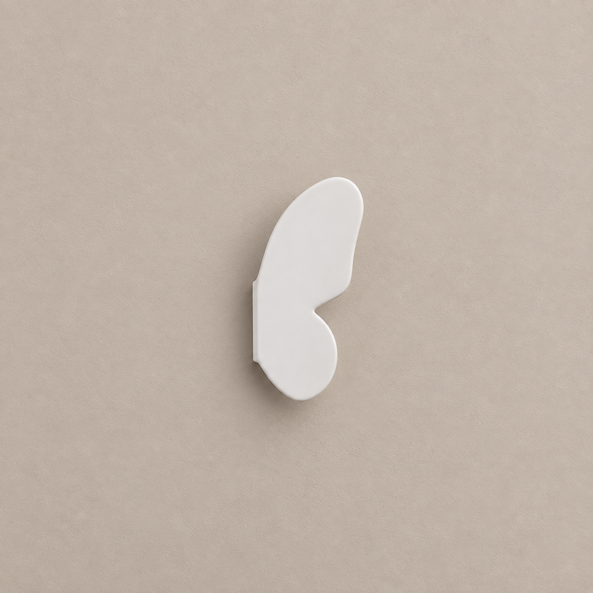 one white right butterfly-wing cabinet knob on a warm taupe background