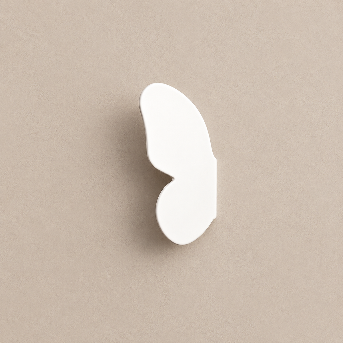 one white left butterfly-wing cabinet knob on a warm taupe background