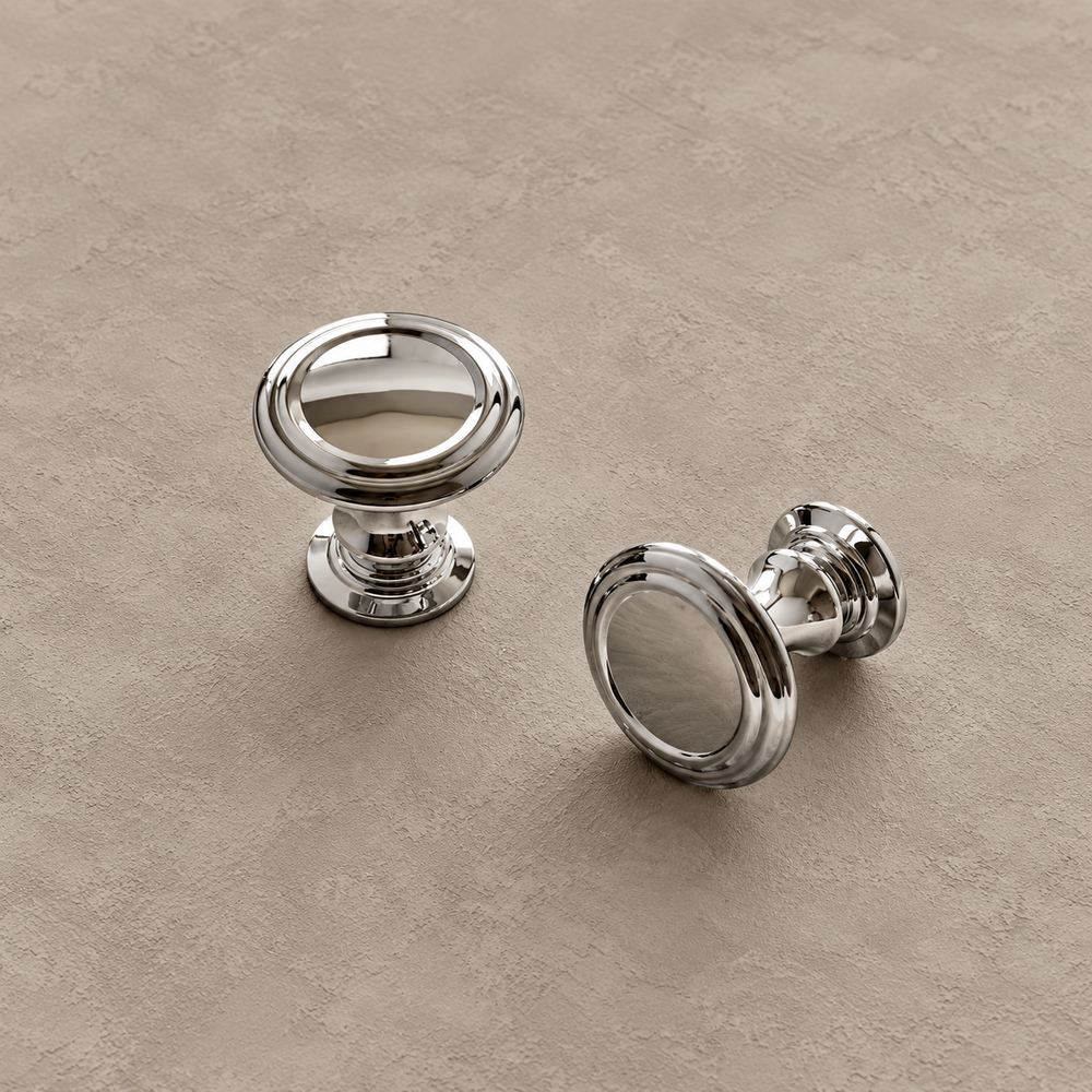Chrome round cabinet knobs with stepped bases on taupe plaster