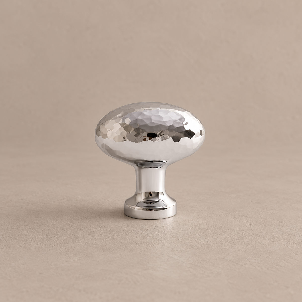 chrome hammered oval knob on warm taupe studio surface