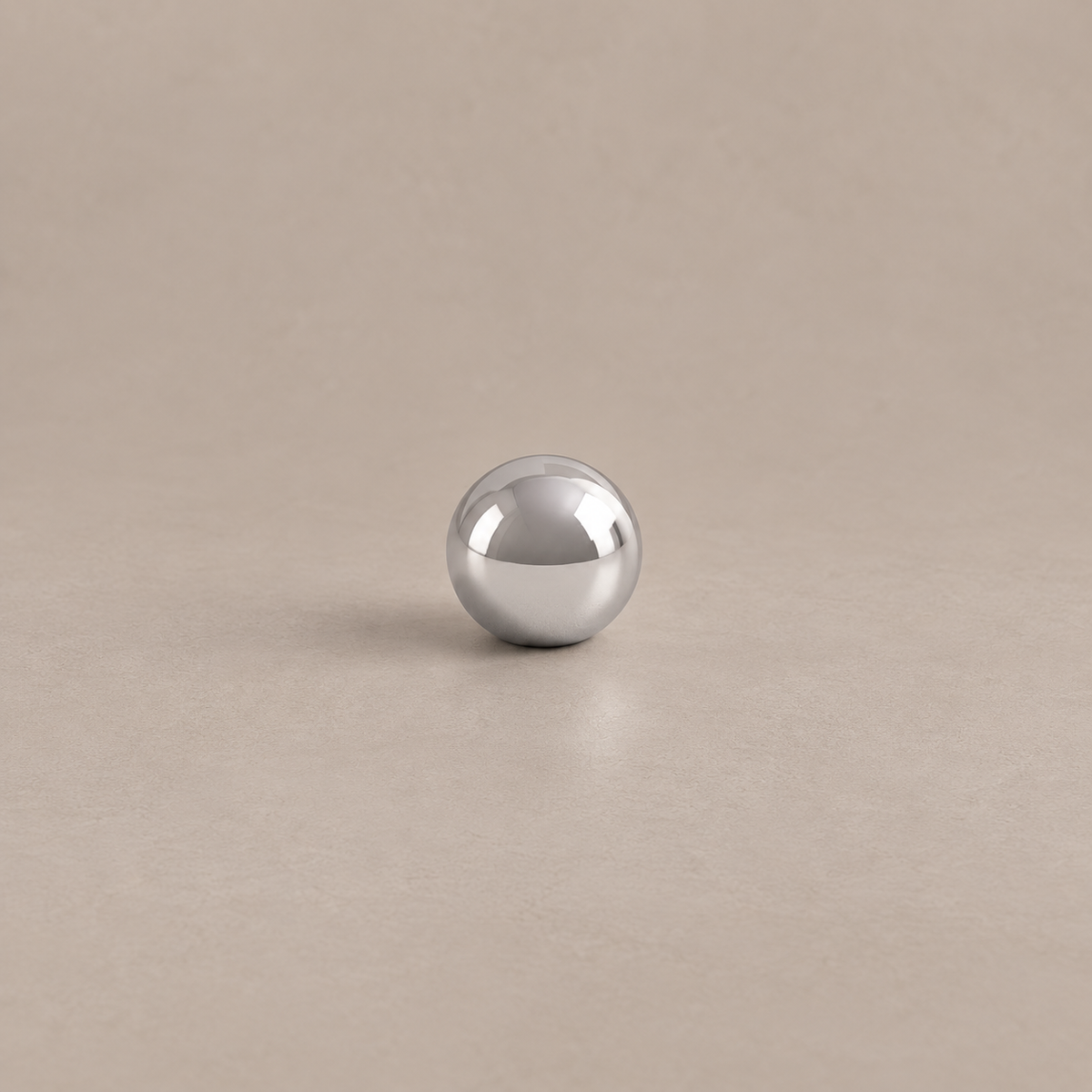 Polished chrome spherical cabinet knob with low profile on warm taupe surface