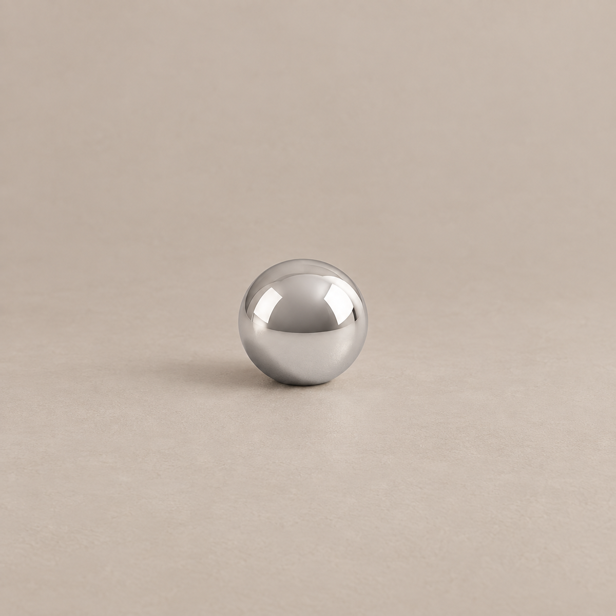 Polished chrome spherical cabinet knob with low profile on warm taupe surface