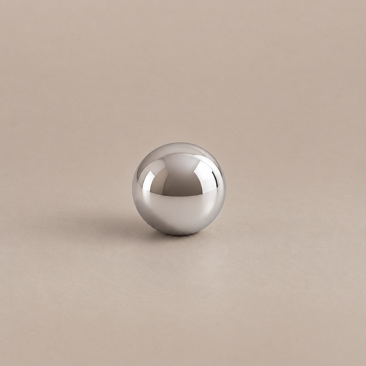 Polished chrome spherical cabinet knob with low profile on warm taupe surface