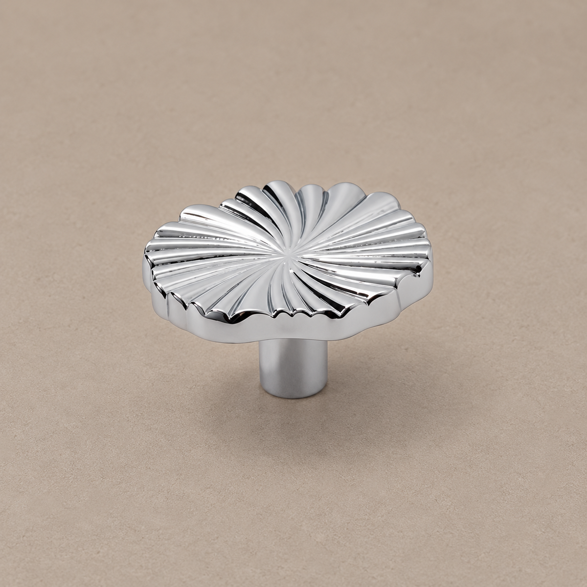 chrome ruffled knob on warm taupe studio surface