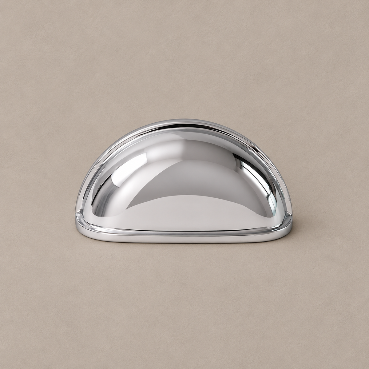 chrome smooth cup handle on warm taupe studio surface
