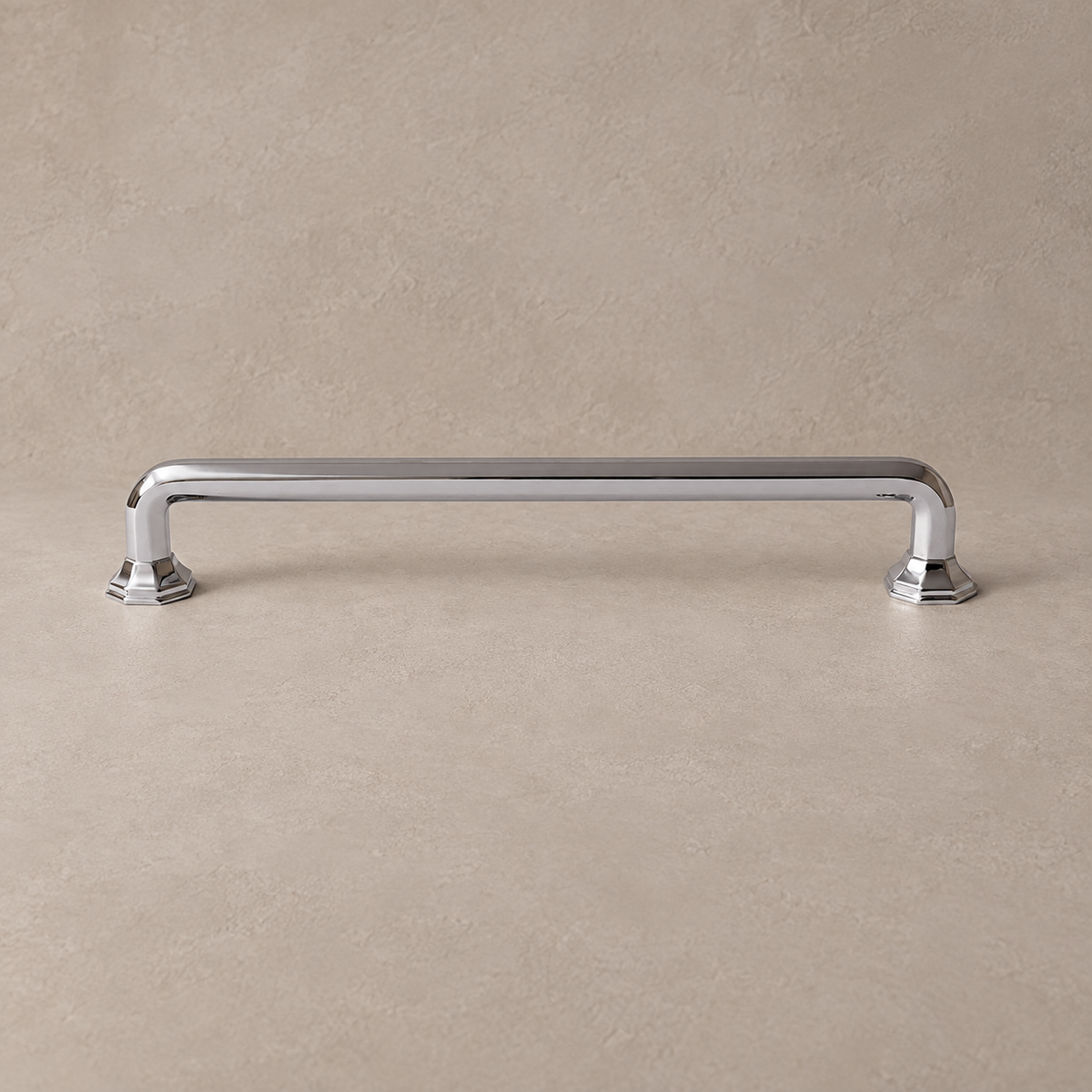 Chrome square bar cabinet pull with stepped feet on a taupe studio surface