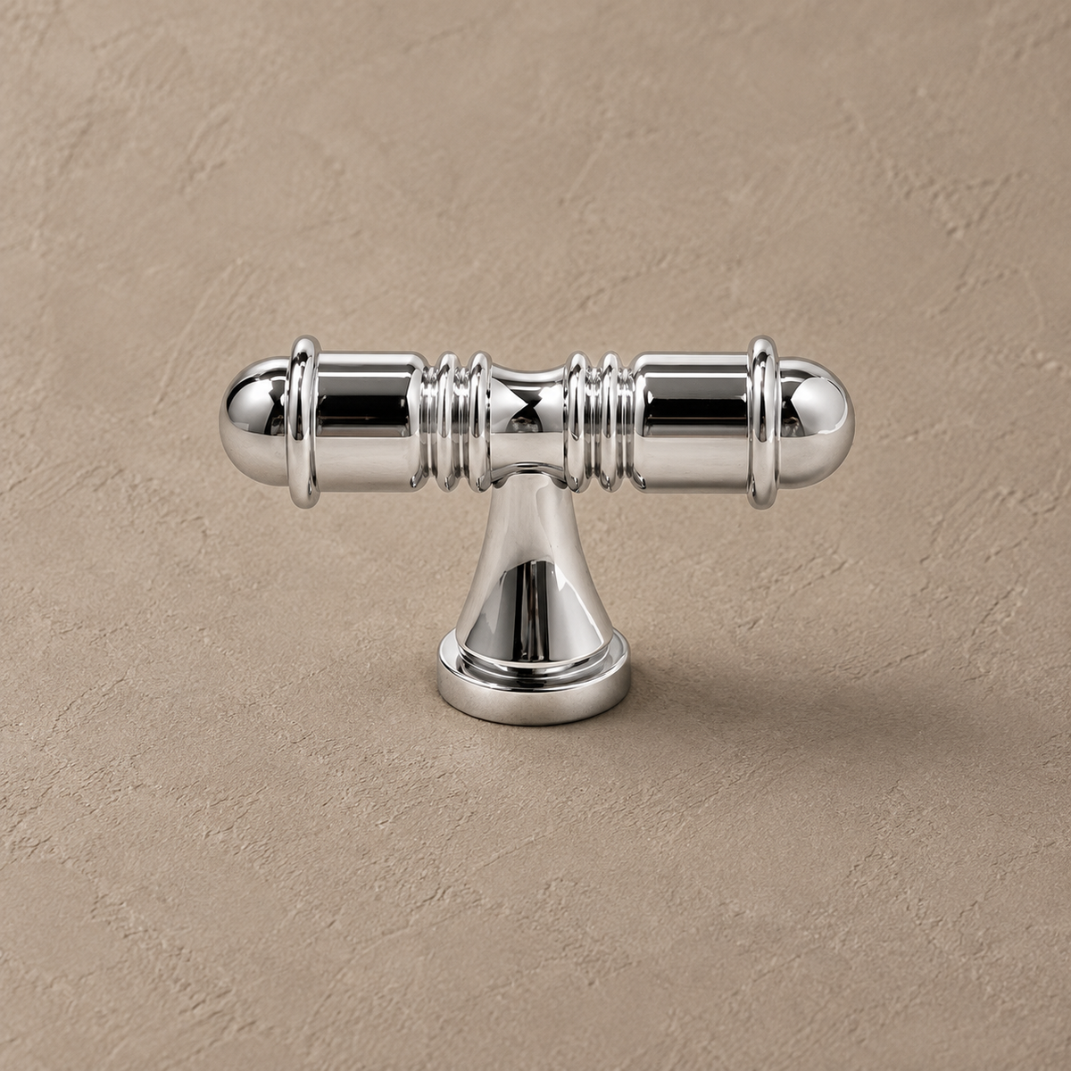 Chrome turned cabinet t knob detail on warm taupe background