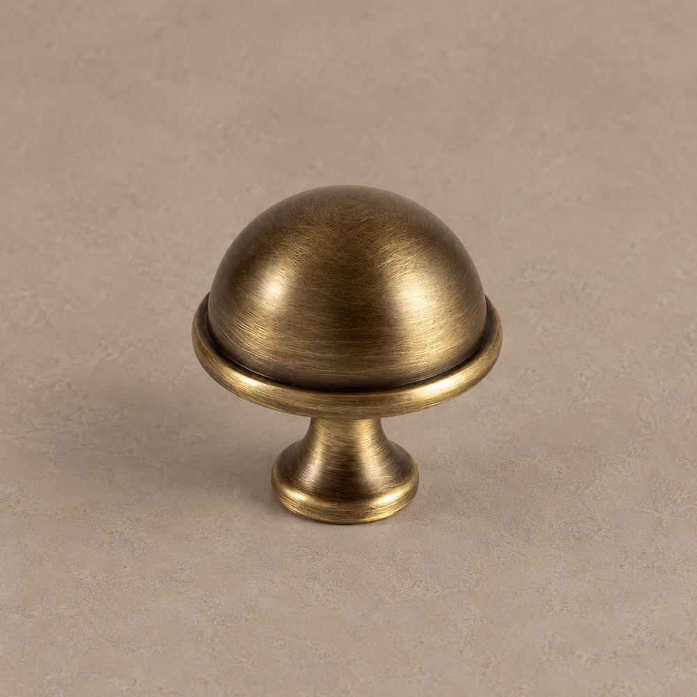 antique brass dome knob on warm taupe surface