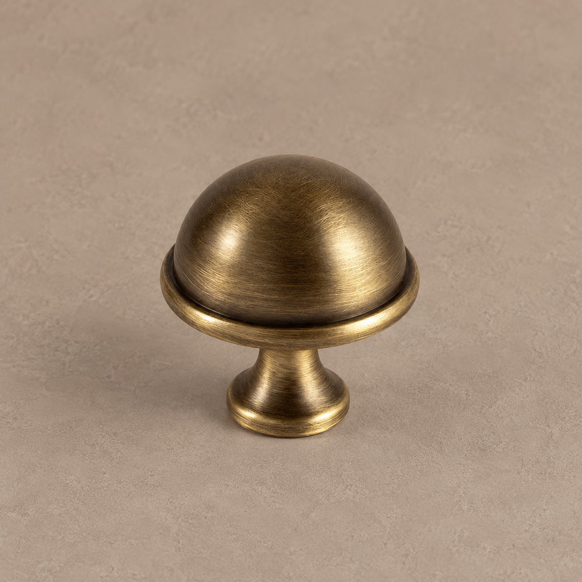 antique brass dome knob on warm taupe surface