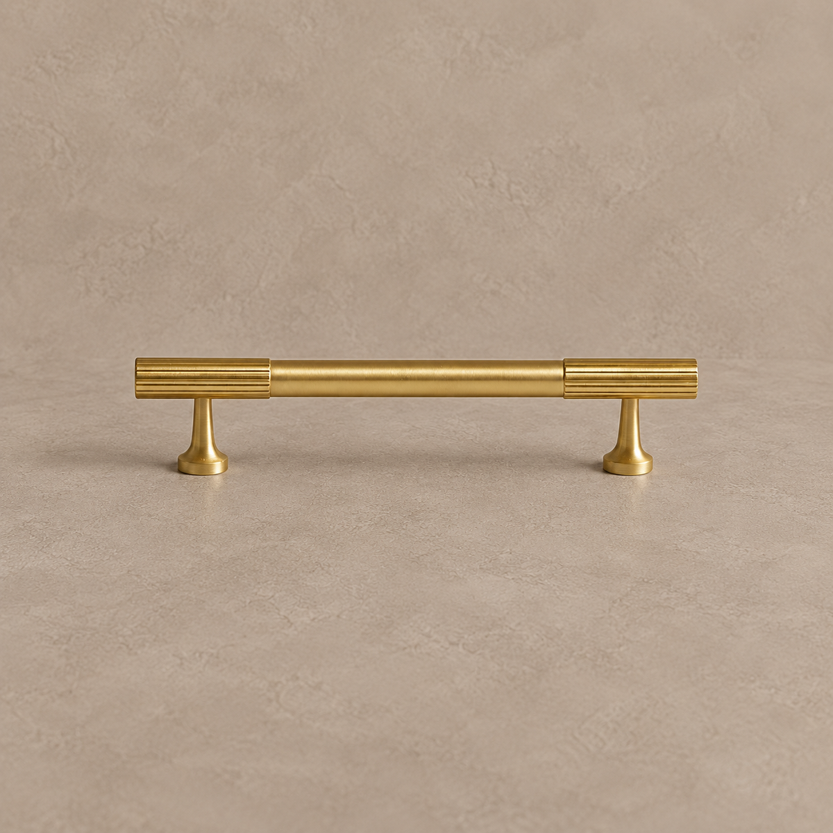 brushed brass fluted cabinet pull on warm taupe studio background