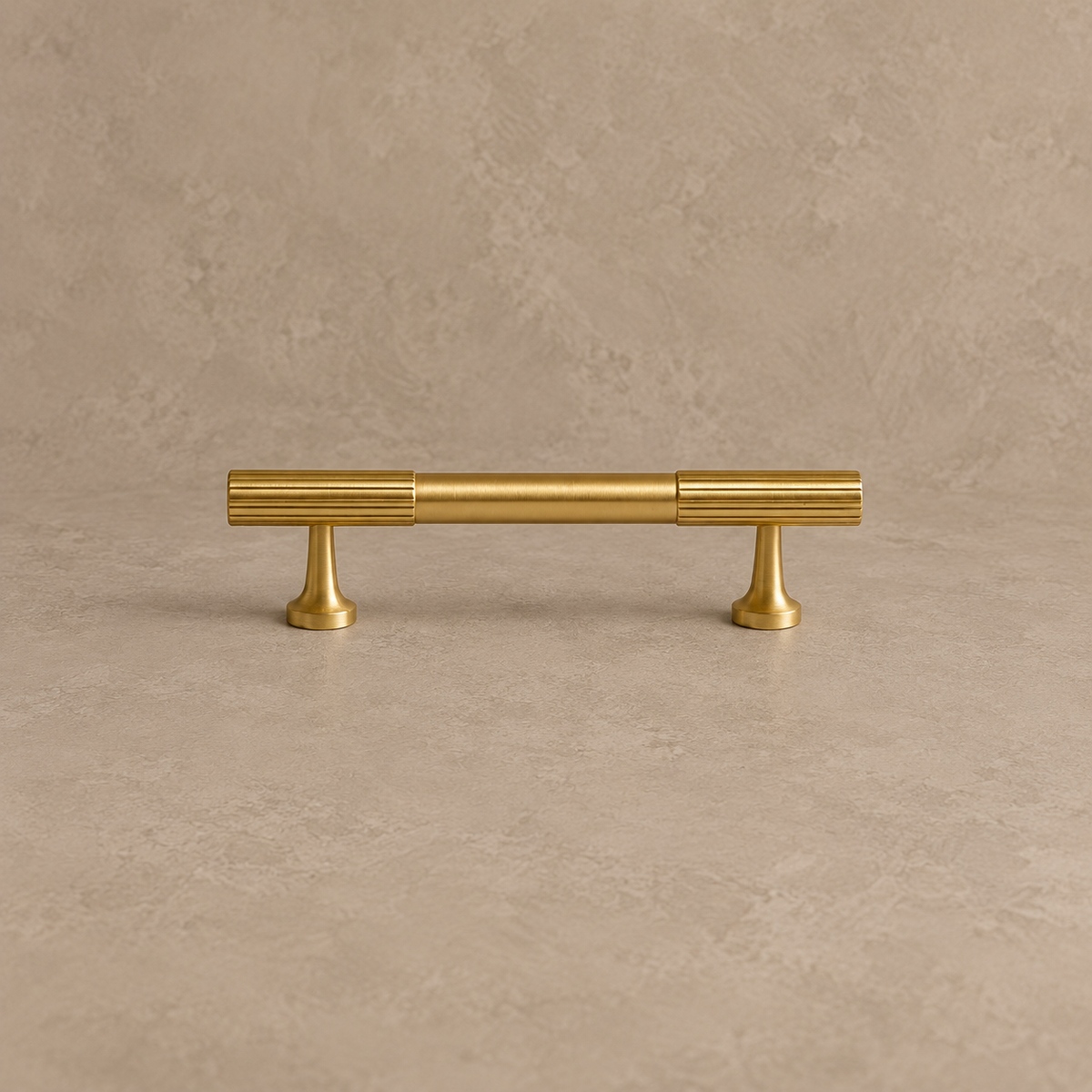 brushed brass fluted cabinet pull on warm taupe studio background