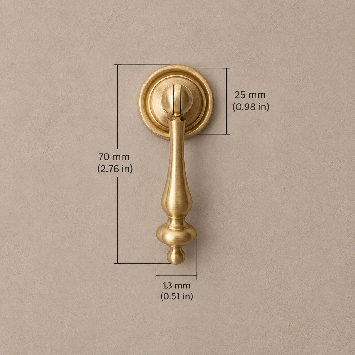Brushed brass pendant cabinet handle, 70 mm overall length, with metric and inch dimensions on taupe background