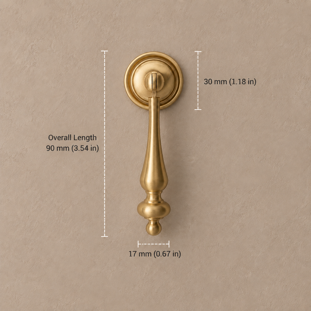 Brushed brass pendant cabinet handle, 90 mm overall length, with metric and inch dimensions on taupe background