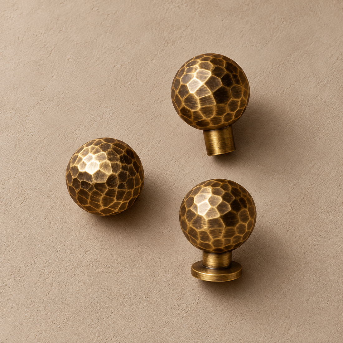 Hand-Hammered Solid Brass Cabinet Knobs — Antique Brass on a warm ivory background