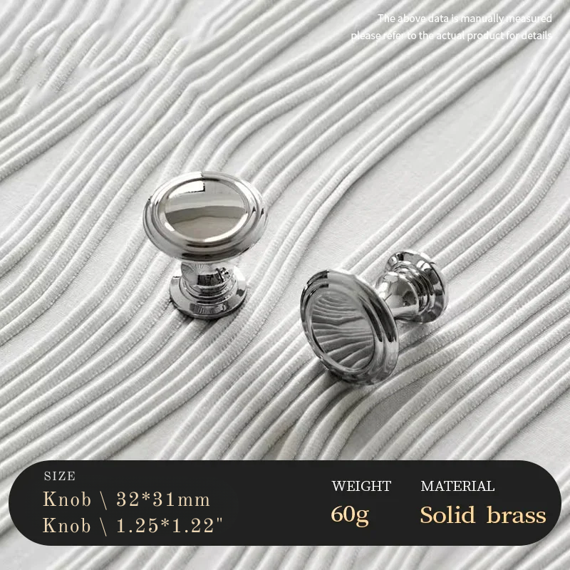 Two silver cabinet knobs on a textured white surface with product details.