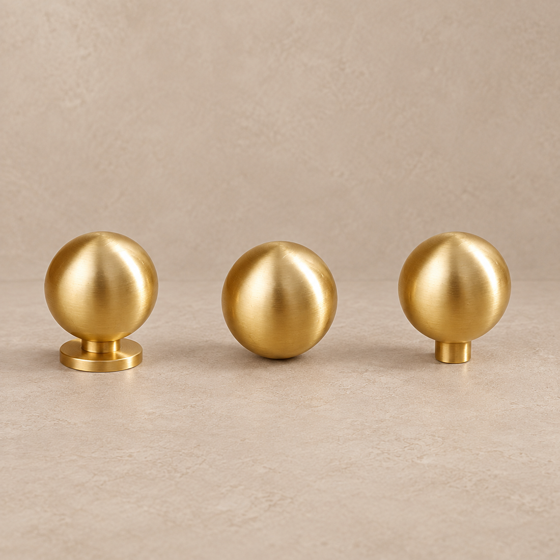 Solid Polished Brass Round Cabinet Knob — Minimalist Ball Design on a neutral stone studio background