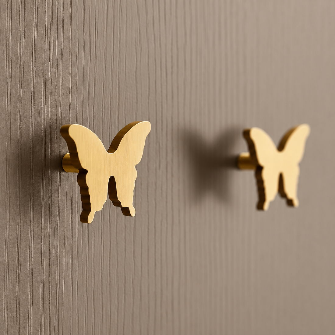 Brass butterfly cabinet knobs mounted on taupe doors