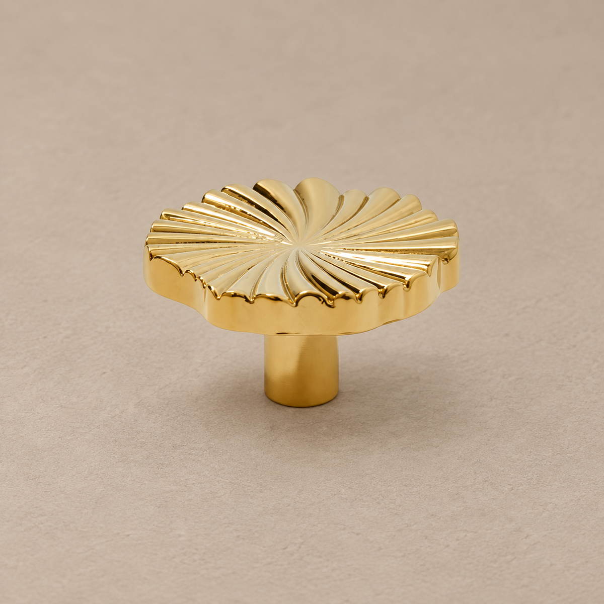 polished brass ruffled knob on warm taupe studio surface