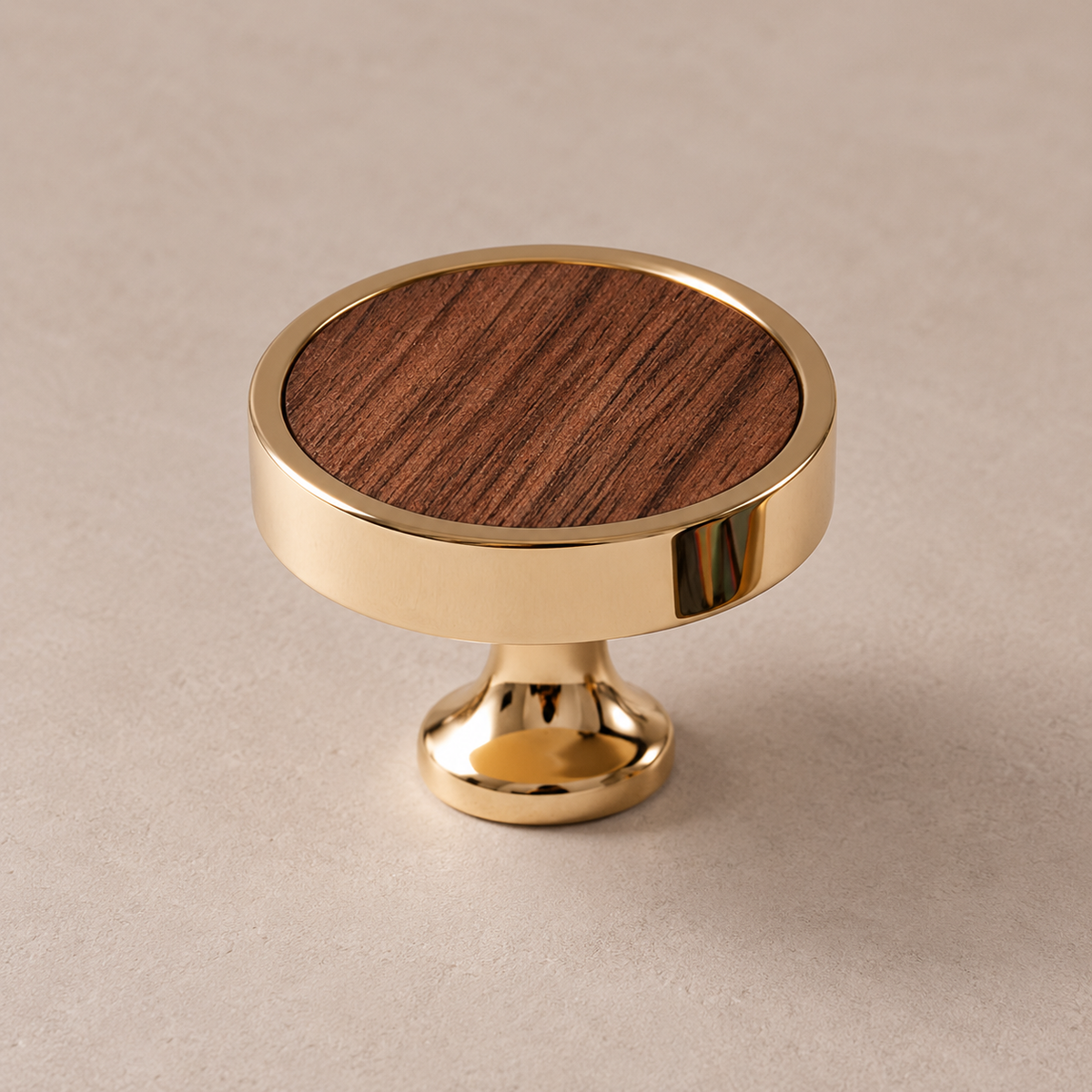 Polished PVD brass cabinet knob with walnut inlay on taupe studio background