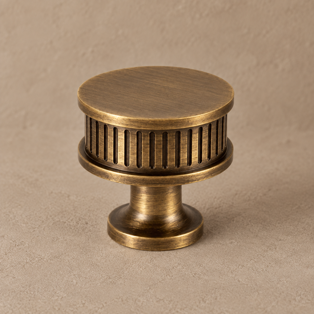 Antique brass ribbed cabinet pull on warm taupe plaster
