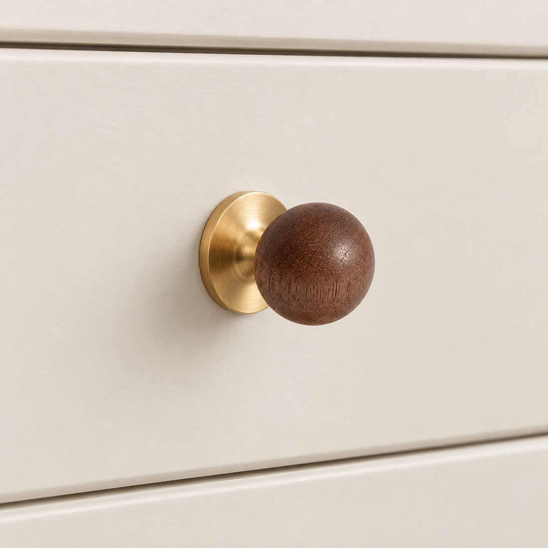 Walnut ball cabinet knobs with brass and chrome bases in a premium studio setting